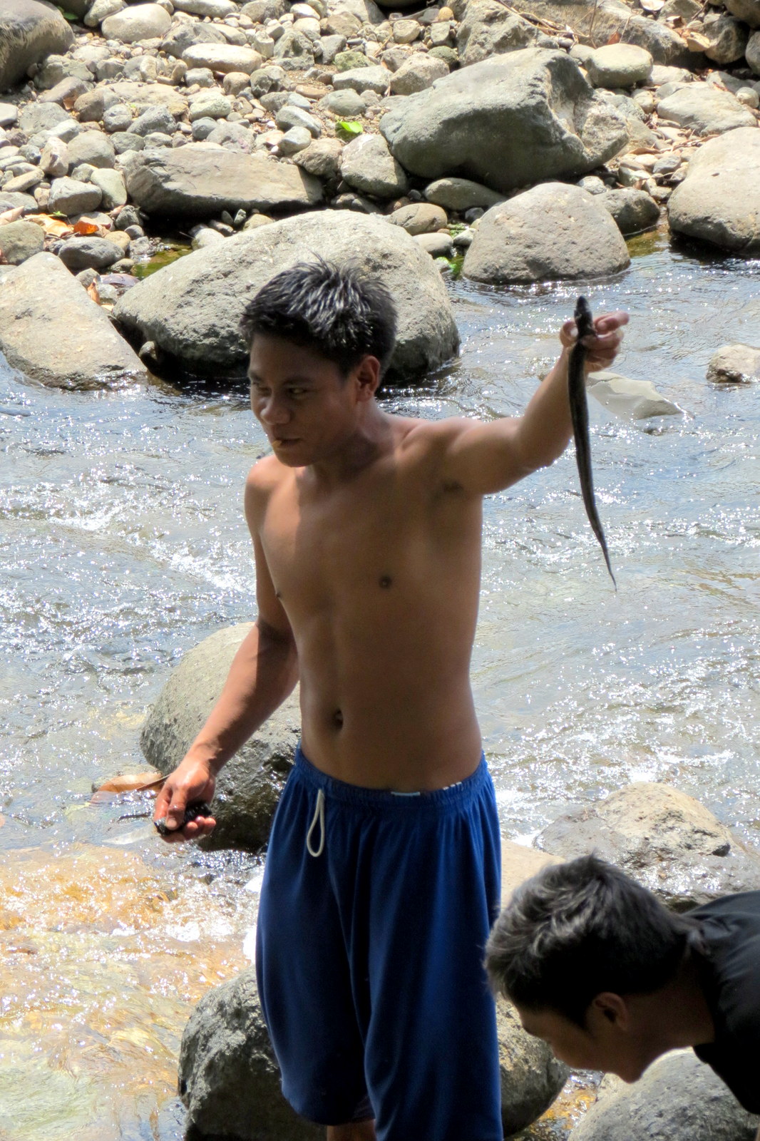 fisherman-catches-eel-in-stream-near-kabigan-falls