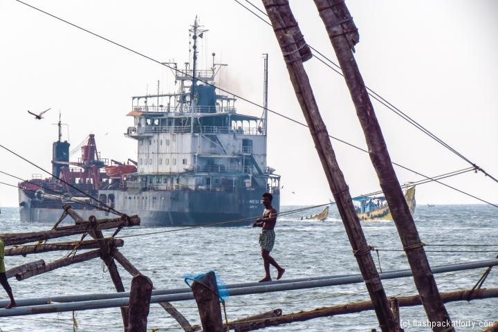 man-on-chinese-fishing-nets-fort-cochi