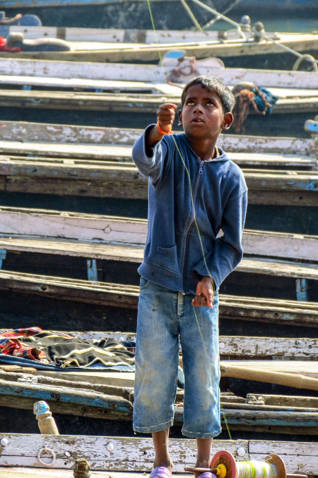 young-boy-concentrates-on-kite-flying-varanasi